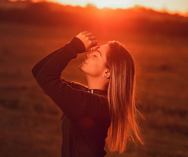 Silhouette of a person in a meditative pose against a sunset.